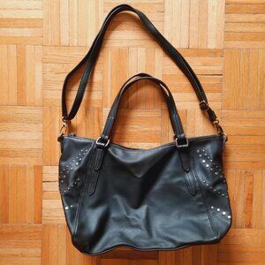 Black studded handbag with short hand strip and removable shoulder strap